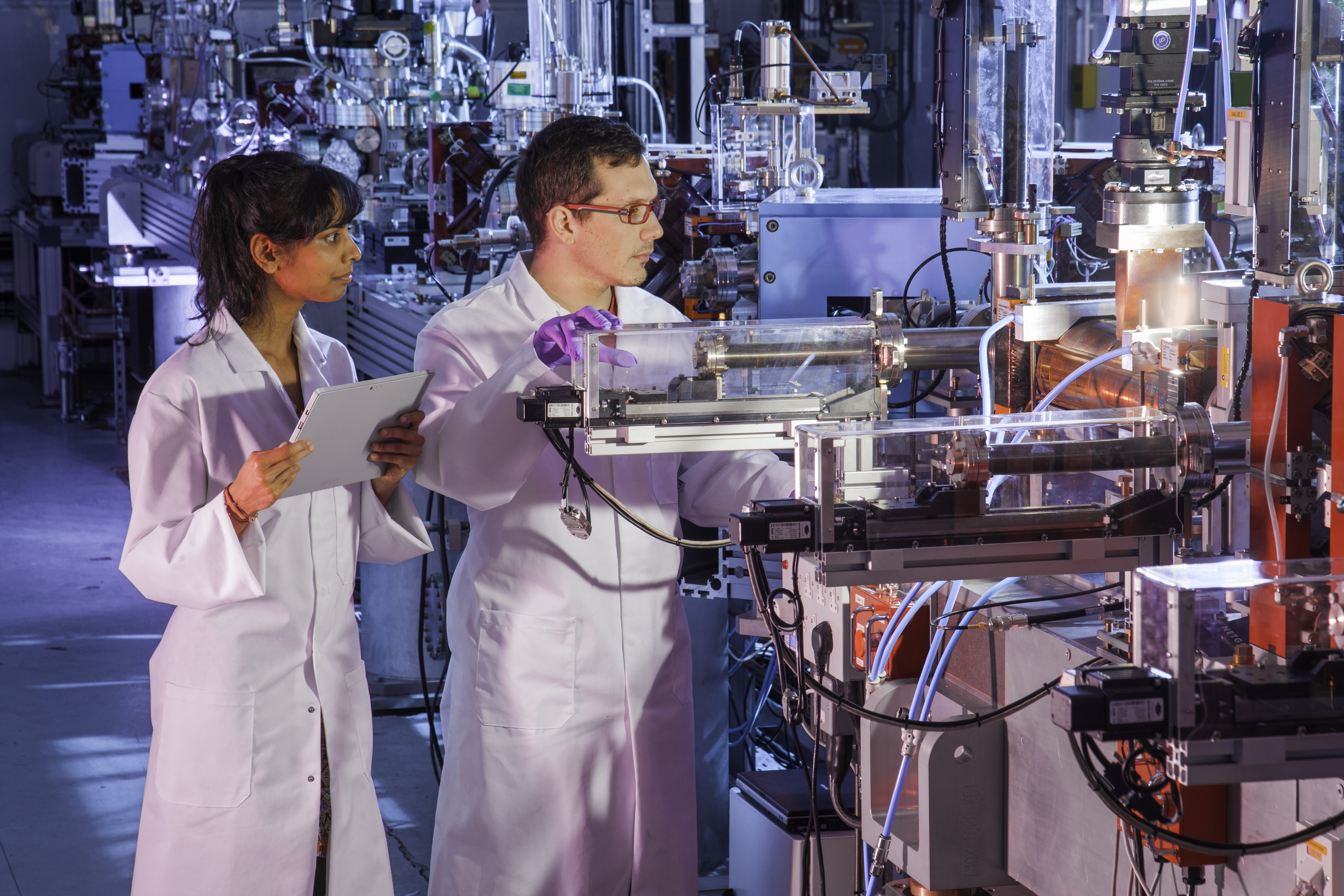Two scientists attending to a particle accelerator